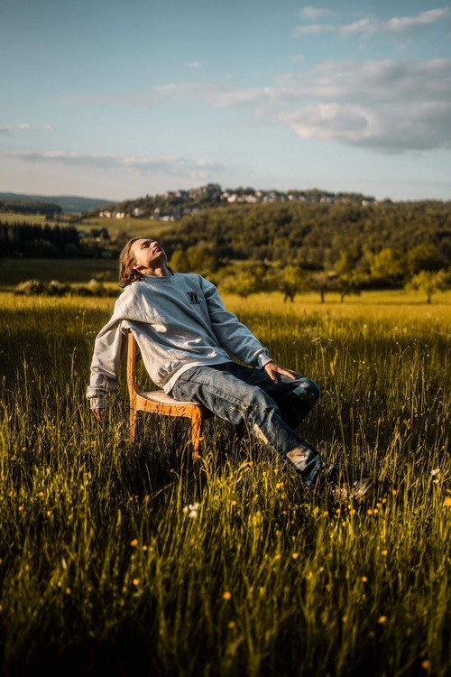 Person relaxing on bench at Walk Haven with vast open fields around them